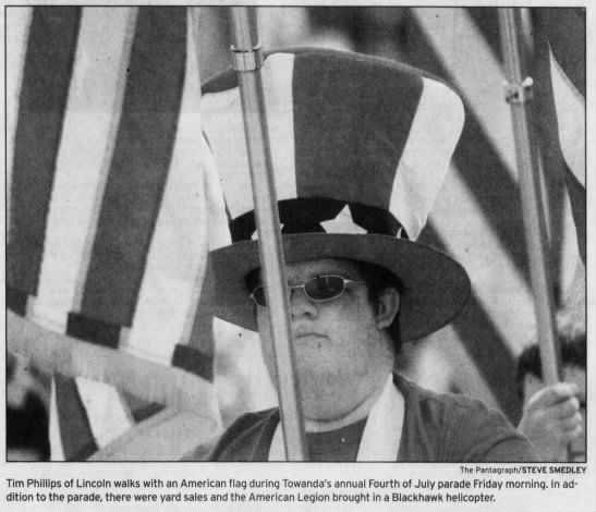 Tim Phillips of Lincoln walks with American flag